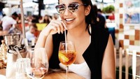 Es lemon tea tengah diseruput Angel saat santai di siang hari. Senyum ceria Angel hampir saja mengalahkan manisnya lemon tea. Foto: instagram @angelpieters