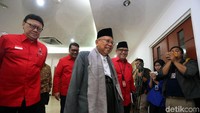 Maruf Amin datang menggunakan peci, kemeja putih, dan jas abu-abu dengan bawahan sarung.