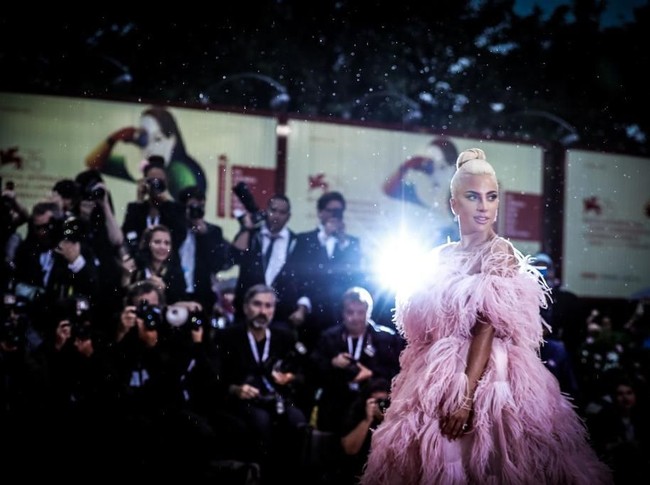 Tak kalah mencuri perhatian, gaya Lady Gaga di screening film yang dibintanginya, A Star Is Born, Jumat (31/8/2018). Untuk momen spesial tersebut, penyanyi bernama lengkap Stefani Joanne Angelina Germanotta ini membungkus tubuhnya dengan gaun pink strapless megar penuh bulu nan dramatis dari Valentino Couture. (Foto: Vittorio Zunino Celotto/Getty Images)