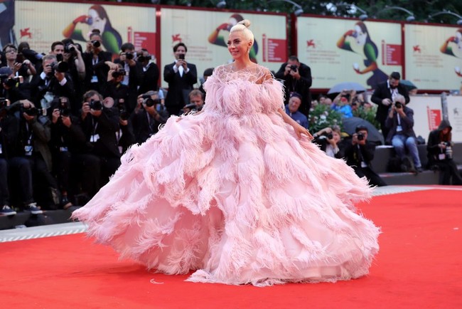 Gaya busananya pun sukses menarik atensi. Untuk momen spesial tersebut, penyanyi bernama lengkap Stefani Joanne Angelina Germanotta ini membungkus tubuhnya dengan gaun pink strapless megar penuh bulu nan dramatis. Foto: Vittorio Zunino Celotto/Getty Images