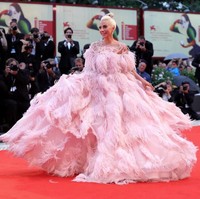 Gaya busananya pun sukses menarik atensi. Untuk momen spesial tersebut, penyanyi bernama lengkap Stefani Joanne Angelina Germanotta ini membungkus tubuhnya dengan gaun pink strapless megar penuh bulu nan dramatis. Foto: Vittorio Zunino Celotto/Getty Images