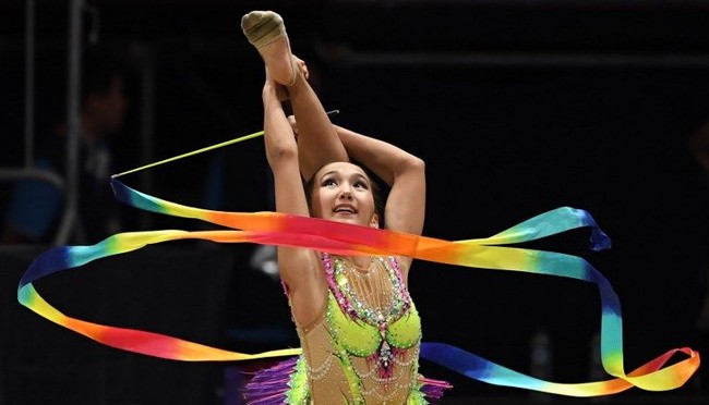 Selain Alina Adilkhanova, Kazakhstan juga punya atlet senam ritmik muda lainnya yang mencuri perhatian. Dia adalah Dayana Abdirbekova. Bersama Alina, pada cabang senam ritmik beregu, dia ikut mempersembahkan emas untuk Kazakhstan di Asian Games 2018. Foto: dok. AFP.