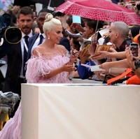 Di tengah rintikan hujan, Lady Gaga juga menyempatkan diri menyapa penggemarnya. Foto: Vittorio Zunino Celotto/Getty Images