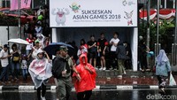 Potret warga yang reka basah-basahan demi menyaksikan penutupan Asian Games 2018.