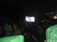 Pakai Jas Hujan dan Payung, Warga Setia Nobar Lewat Layar di GBK