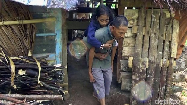 Dasirin saat gendong anaknya, Wiwit yang lumpuh keluar dari kandang kerbau.