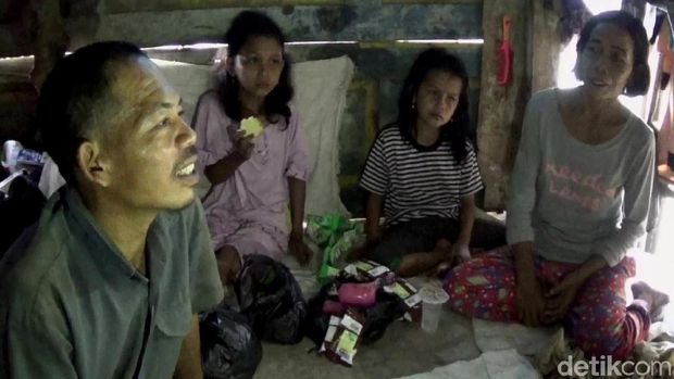 Dasirin bersama keluarganya di dalam kandang kerbau yang ditinggalinya.