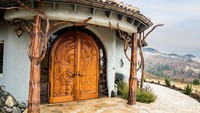 Dari tampilan depan, sudah tampak pintu utama dari rumah ini memiliki ukuran yang besar. Mengutip dari laman express, pintu ini mirip seperti gerbang utama Minas Tirith dan juga Helms Deep di Film Trilogi The Lord Of The Rings. Istimewa/Dok. Express.co.