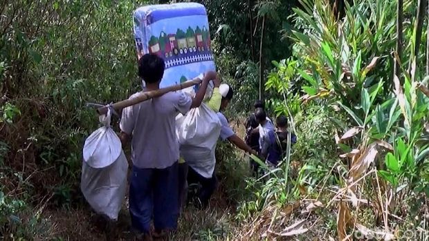 Warga gotong royong membantu evakuasi keluarga Dasirin. 