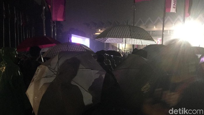 Pakai Jas Hujan dan Payung, Warga Setia Nobar Lewat Layar di GBK