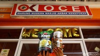Penjaga menunjukan produk yang dijual di OK Oce Mart.