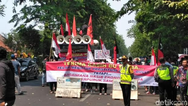 Warga mendukung Dolly dibuka membentangkan psoter/