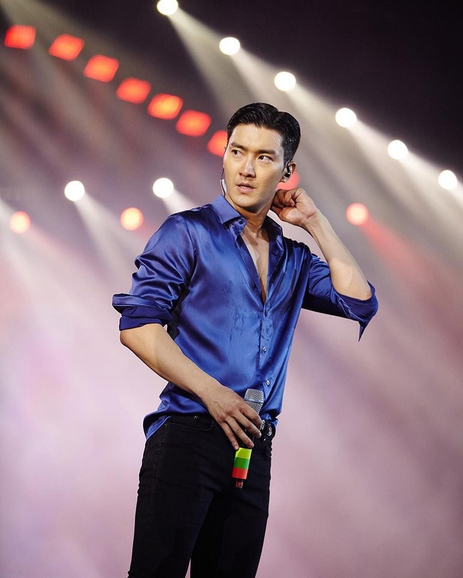 Kemeja pun diaplikasikan Choi Siwon saat tampil di panggung. Namun kali ini ia memilih yang materialnya lebih mewah. Kemeja berbahan satin itu pun dipadukan dengan celana jeans hitam sehingga tak tampak kaku. Foto: Instagram @siwonchoi