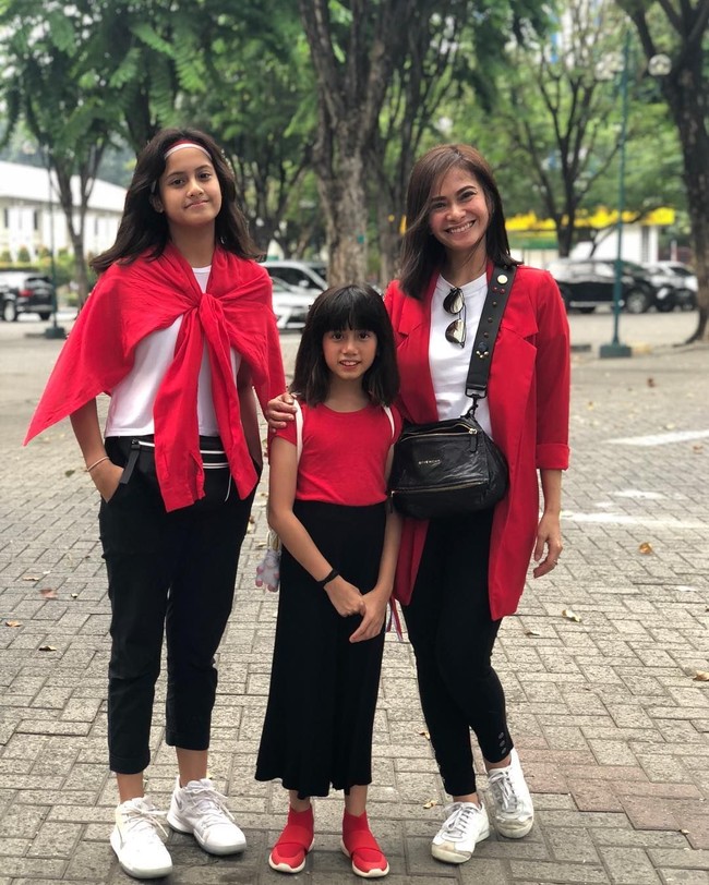 Penutupan Asian Games 2018 juga tak dilewatkan presenter Ersa Mayori dan keluarga. Ia tampil preppy-chic dengan blazer merah panjang dan kaus putih, dipadu celana panjang hitam dan sneakers putih, berikut tas selempang hitam Givenchy. (Foto: Instagram)