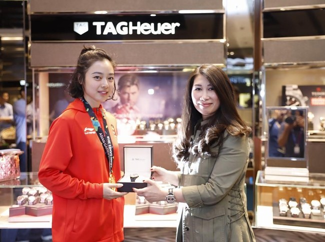 Memakai jaket tim Indonesia dengan medali emas yang terkalung di lehernya, Lindswell Kwok menerima apresiasi jam tangan TAG Heuer dari perwakilan Time International. (Foto: Dok. Time International)