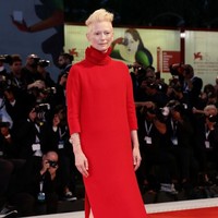 Kompak dengan Dakota di screening film Suspiria, aktris Tilda Swinton. Aktris pemenang Oscar itu memakai gaun merah turtle-neck. (Foto: Getty Images)