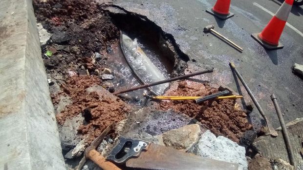 Petugas menggali aspal untuk memperbaiki pipa ledeng yang bocor
