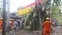 Pesawat berwarna kuning dan merah itu tampak jatuh di pekarangan warga, Selasa (4/9/2018). Garis polisi telah dipasang di sekitar lokasi kejadian. (Foto: Dok Basarnas DIY)