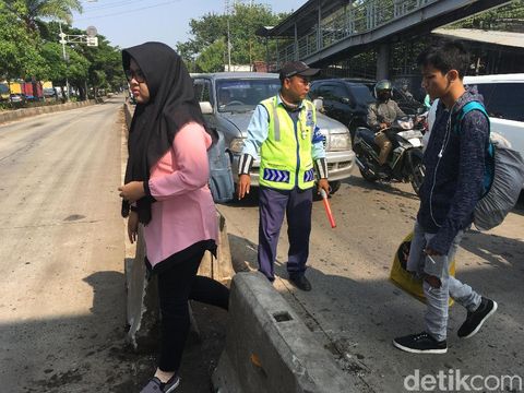 Masyarakat mesti menyeberang untuk bisa masuk ke halte TransJ