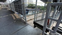 Jembatan penyeberangan orang itu pun hanya ditopang tiang besi disalah satu sisi ujungnya. Sementara bagian tangga dan lantai tengah JPO yang renggang belum juga disambung.