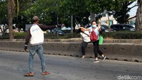 Para tukang ojek yang mangkal di sekitar JPO turun tangan membantu warga yang ingin menyeberang.