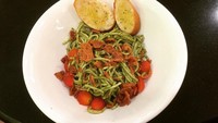 Seporsi pesto spaghetti ini disajikan dengan pelengkap roti baguette. Lalu irisan tomat ceri dan beef bacon dijadikan topping. Foto : instagram @firdauspay