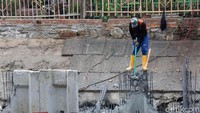 Proses pemasangan turap ini dilakukan sejak pagi hari hingga sore hari. Seorang petugas tengah melakukan pengerukan sedimen tanah di sisi kiri dan kanan Kali Grogol yang ketinggiannya mencapai 3 meter.