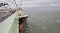 Badan kapal tanker itu sempat menempel ke bagian samping jembatan. Saat insiden ini terjadi, kapal tanker itu dalam keadaan kosong alias tidak membawa muatan. Tidak ada korban jiwa dalam insiden ini. Foto: JAPAN COAST GUARD via Japan Times