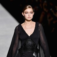 Tak cuma di front row, wajah-wajah tenar juga mewarnai catwalk Tom Ford. Salah satunya Gigi Hadid yang mendapat mandat memeragakan gaun hitam bersayap dengan korset kulit buaya. (Foto: Getty Images)
