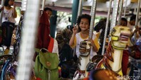 Anak-anak naik komidi putar.