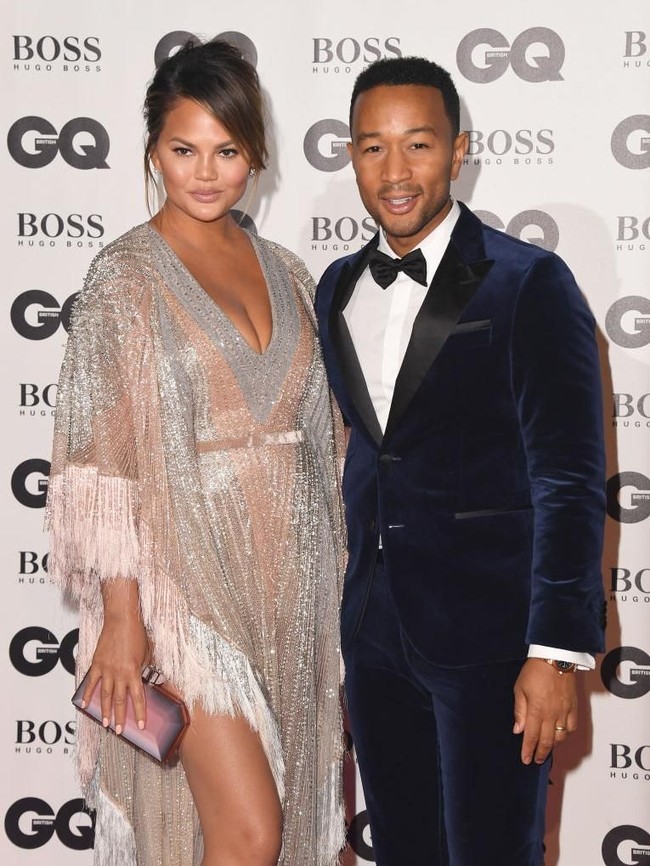 Sang istri pun tak kalah modisnya. Dengan gaun Labourjoisie bermodel kaftan yang hadir dengan belahan dada rendah dan detail fringe, Chrissy yang baru melahirkan anak keduanya Mei lalu memancarkan aura seksinya. (Foto: Getty Images)