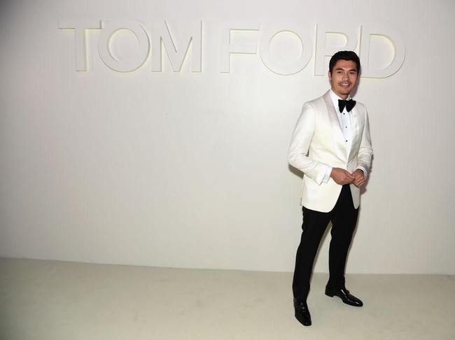 Pemeran utama Crazy Rich Asians, Henry Golding, hadir di fashion show Tom Ford. Ia gagah dalam balutan tuksedo putih rancangan desainer AS tersebut. (Foto: Getty Images)