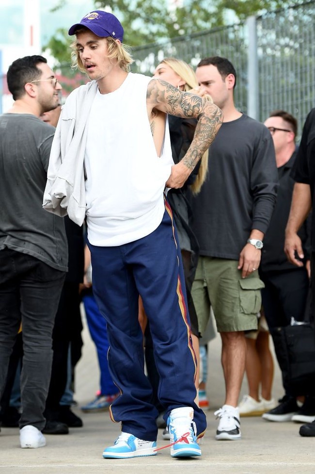 Sementara penampilan Justin Bieber terlihat lebih cuek. Penyanyi 24 tahun ini mengenakan kaos oversized, track pants, topi baseball dan sweater. Foto: Getty Images