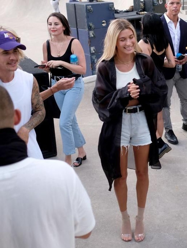 Gaya Hailey santai namun stylish dengan padanan crop top, denim shorts, high heels dan kemeja transparan. Foto: Getty Images