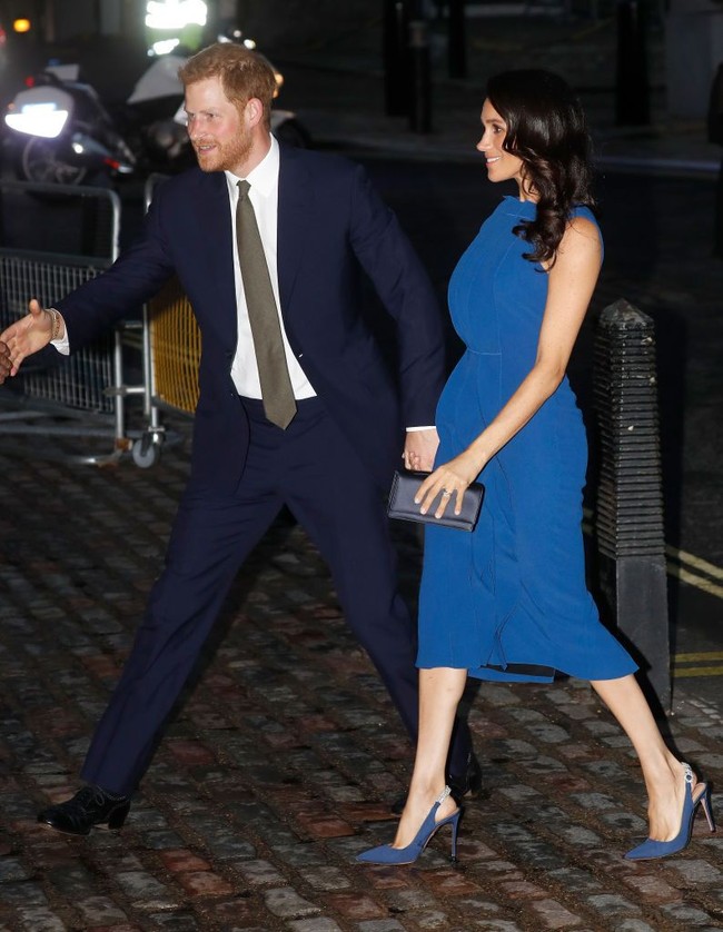 Meghan Markle memadukan gaun birunya dengan sepatu sling back berwarna senada dari brand Altuzarra. Foto: Getty Images