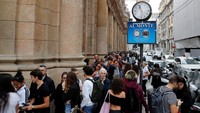 Orang-orang terlihat di depan pintu masuk Starbucks Reserve Roastery pada hari pembukaan di pusat kota Milan. Stefano Rellandini/Reuters.