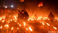 Warga menyalakan obor yang membentuk tulisan Sigemplong Batang di hamparan kebun kentang milik warga.