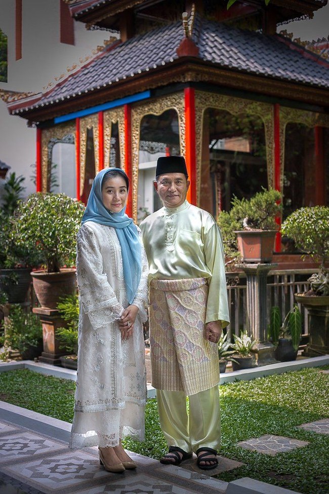 Cantiknya Rika Kato saat berpose bersama Yusril Ihza Mahendra pada Hari Lebaran 2018. Memakai baju kurung berwarna putih, dia melengkapi gaya elegannya dengan kerudung biru dan sepatu berwarna nude. Foto: Twitter