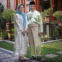 Cantiknya Rika Kato saat berpose bersama Yusril Ihza Mahendra pada Hari Lebaran 2018. Memakai baju kurung berwarna putih, dia melengkapi gaya elegannya dengan kerudung biru dan sepatu berwarna nude. Foto: Twitter