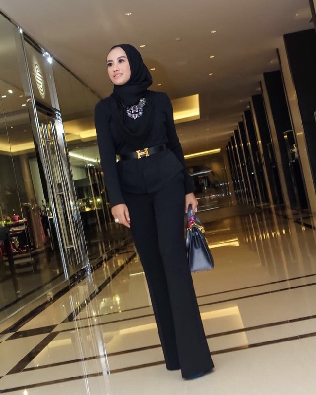 Shinta Bachir tampil formal dengan setelan bergaris tegas dalam warna hitam. Tambahan belt berlogo Hermes emas di pinggang tidak hanya mempertegas siluet pinggang tapi membuat padanan serba hitam tak terkesan monoton. Foto: Dok. Instagram/Shinta Bachir