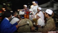 Sebagian peserta mengikuti pawai menggunakan mobil bak terbuka.