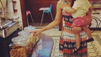 Wah, berkunjung ke sebuah restoran di wilayah Ciamis, Riri telihat menggendong seorang balita. Ia terlihat memilih beberapa camilan yang tersaji di dalam toples besar. Hayo mau pilih yang mana? Foto: Instagram rianarizki