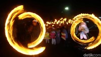 Sebagian peserta melakukan atraksi menggunakan obor yang dibawanya. Obor diputar membentuk lingkaran.