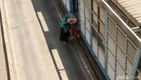 Dua orang penumpang TransJakarta ini lebih memilih menyeberang lewat jalan raya, padahal aksi ini sangat berbahaya.