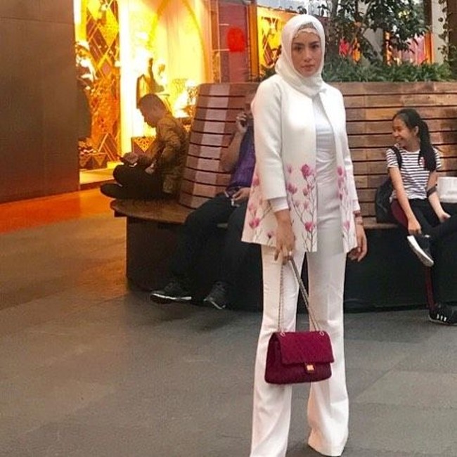Tampilan serba putih yang formal, tampak lebih feminin dengan detail corak di bagian bawah blazer. Warna motif pun tampak senada dengan tas quilted miliknya. Foto: Dok. Instagram/Shinta Bachir