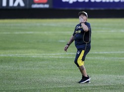Diego Maradona membalas sambutan penonton yang sudah memadati stadion demi melihat latihan perdananya. (Carlos Ramirez/Getty Images)