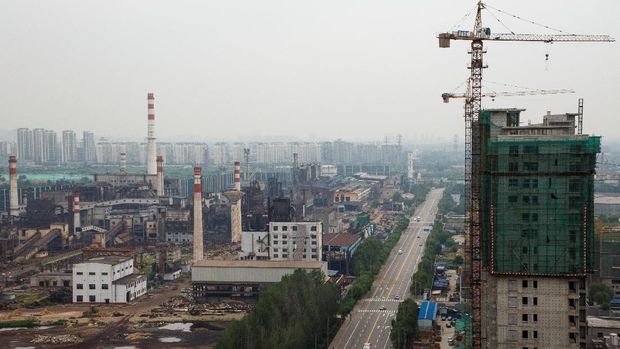 abrik Baja dan Besi Guofeng yang telah dinonaktifkan dan sebuah gedung apartemen yang sedang dibangun di Tangshan, provinsi Hebei, China, August 22, 2018. Picture taken August 22, 2018.  REUTERS/Thomas Peter