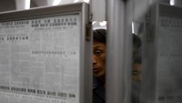 Beberapa penumpang nampak serius membaca surat kabar yang dipajang di area stasiun bawah tanah Pyongyang. Reuters/Danish Siddiqui.