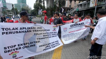 Massa berdemo di bagian belakang gedung Pasaraya Blok M di Jalan Iskandarsyah II. Massa membawa berbagai atribut demonstrasi seperti bendera dan spanduk.