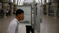Seorang penumpang nampak serius membaca koran di stasiun. Reuters/Danish Siddiqui.